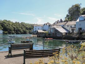 An outdoor area with benches and boats at Cider Press Cottage in Crafthole