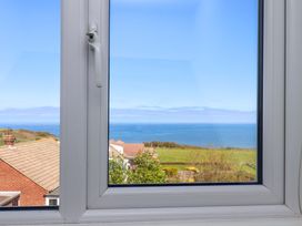 A window view of the ocean and landscape at Cozy Cottage
