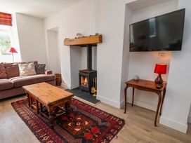 A living room with a sofa, coffee table and fireplace at Cozy Cottage