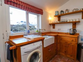 A kitchen with a sink and washing machine at Cozy Cottage in 