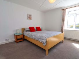 A bedroom with a bed and bedside table at Cozy Cottage