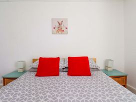 A bed with red cushions and lamps in a bedroom at Cozy Cottage