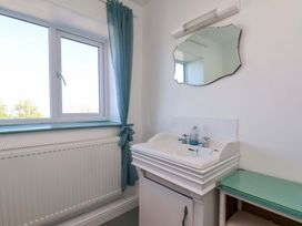 A bathroom with a sink and a window at Cozy Cottage