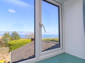 A window with a view of the ocean and sky at Cozy Cottage