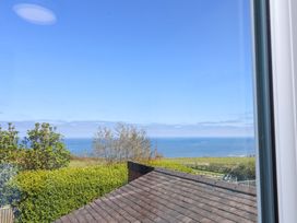 A view of the ocean and greenery from a building at Cozy Cottage