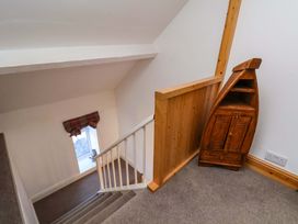 A staircase with a window and wooden cabinet at Cozy Cottage