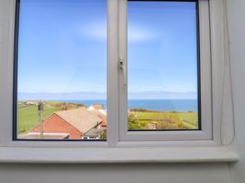 A view of ocean and landscape from a window at Cozy Cottage in 