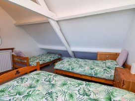 A bedroom with beds and a nightstand at Cozy Cottage