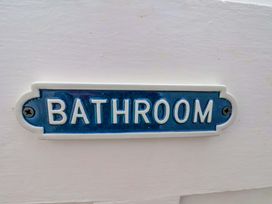 A bathroom sign at Cozy Cottage in 