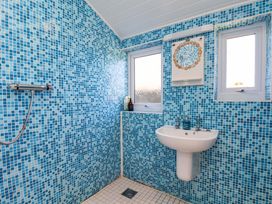 A bathroom with a sink and shower at Cozy Cottage 