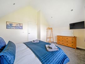 A bedroom with a bed and dresser at Lodge 4 near Brigg