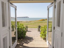 A view from an open door showcasing the sea and greenery at The Bolthole in Newport