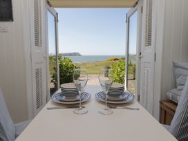 A dining area with a table set for two with a view of the sea at The Bolthole Newport