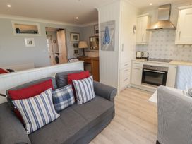 A living room with a sofa and kitchen area at The Bolthole in Newport