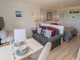 A living room with a sofa and dining table at The Bolthole in Newport