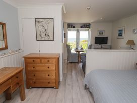 A studio with bed, dresser, and table at The Bolthole in Newport