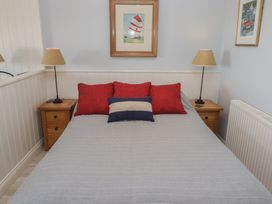 A bedroom with a bed and nightstands at The Bolthole in Newport