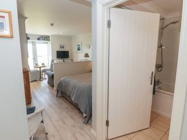 A bedroom with a bed, tv and door leading to a bathroom at The Bolthole in Newport