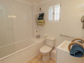 A bathroom with a bathtub toilet sink and towels at The Bolthole in Newport