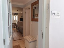 An entryway with a bench and mirror at The Bolthole in Newport