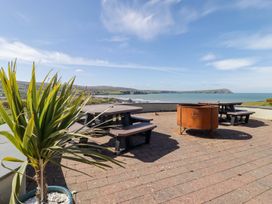 An outdoor seating area with tables and benches at The Bolthole in Newport