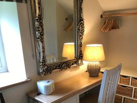 A dressing room with a mirror and a lamp at The Bothy at Lewis Cottage in Spreyton