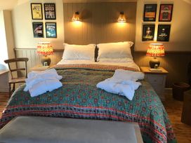 A bedroom with a bed and bedside tables at The Bothy at Lewis Cottage in Spreyton