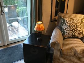 A living room with an armchair and a lamp at The Bothy at Lewis Cottage in Spreyton