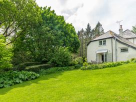 A house with a garden and trees at The Bothy at Lewis Cottage in Spreyton