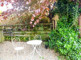 A garden area with a table and chair at The Mews @ Derrybawn, Laragh, County Wicklow