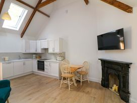 A kitchen with cabinets, stove, sink, table and chairs at The Mews @ Derrybawn, Laragh, County Wicklow