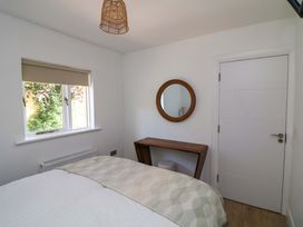 A bedroom with a bed, window, mirror, and table at The Mews @ Derrybawn Laragh, County Wicklow