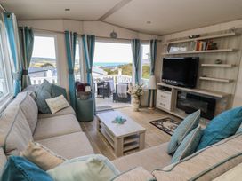 A living room with a sofa and television at Swanny View in Swanage