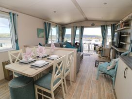 A living room with a dining area and windows offering a view at Swanny View in Swanage