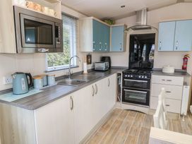 A kitchen with countertop appliances and cabinets at Swanny View in Swanage