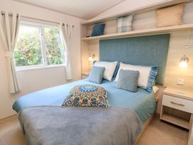 A bedroom with a bed and window at Swanny View in Swanage