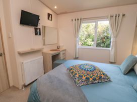 A bedroom with a bed and television at Swanny View in Swanage