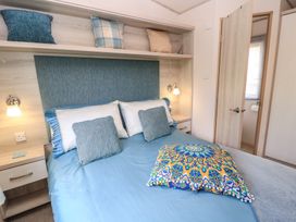 A bedroom with a bed and shelves at Swanny View in Swanage