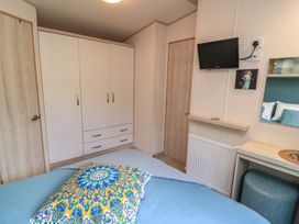 A bedroom with a wardrobe and television at Swanny View in Swanage