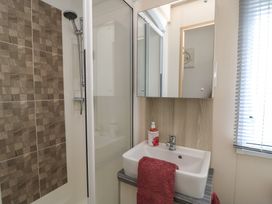 A bathroom with a shower and sink at Swanny View, Swanage
