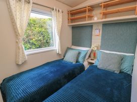 A bedroom with twin beds and a window at Swanny View in Swanage
