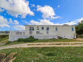 A house with a deck and grass area at Swanny View in Swanage