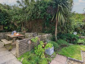 A garden with seating area and plants at Swanny View in Swanage