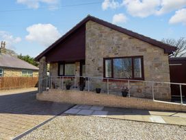 A house with stone exterior and driveway at Willow cottage in Seahouses