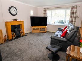 A living room with a television and sofa at Willow cottage in Seahouses