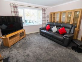 A living room with a television and a sofa at Willow cottage in Seahouses