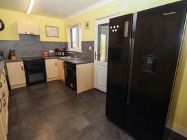 A kitchen with appliances and a doorway at Willow cottage Seahouses