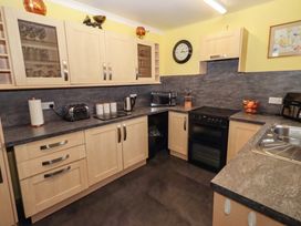 A kitchen with appliances and storage at Willow cottage Seahouses