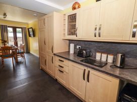 A kitchen with cabinets and appliances at Willow cottage in Seahouses