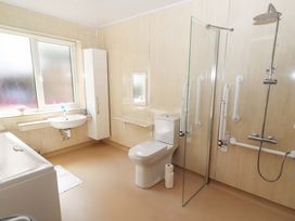 A bathroom with a bathtub, shower, sink, and toilet at Willow cottage in Seahouses